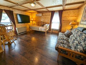 a living room with a couch and a tv at Yellowstone Treasure Guesthouses on the River in Gardiner