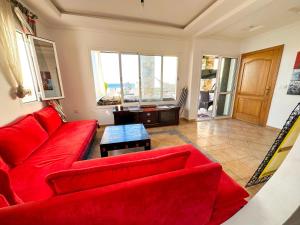 a living room with a red couch and a table at Diamond of Mekkade, Sea view with swimming pool in Oued Laou