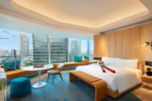 a hotel room with a large bed and a table at W Shanghai - The Bund in Shanghai