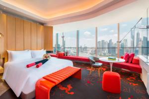 上海市にあるW 上海 ザ バンドのベッドと大きな窓が備わるホテルルームです。