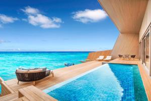 a swimming pool with a view of the ocean at The St. Regis Maldives Vommuli Resort in Dhaalu Atoll