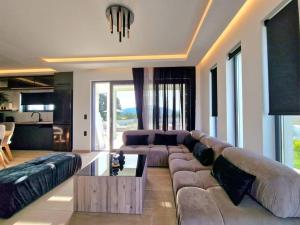 un soggiorno con un grande divano e un tavolo di Villa Gleandra a Laganas