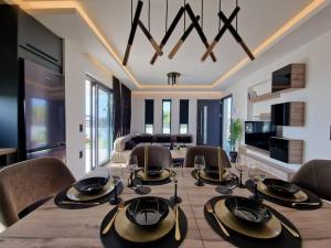 una sala da pranzo con tavolo e sedie e un soggiorno di Villa Gleandra a Laganas