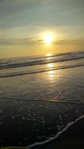 a sunset on the beach with the ocean at El depto de mirta 964 Esquiu in San Bernardo