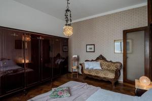 a bedroom with a bed and a couch and a chair at Villa Gabri in Arona