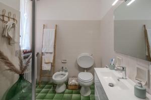 a white bathroom with a toilet and a sink at Villa Gabri in Arona