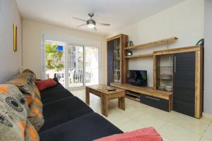 ein Wohnzimmer mit einem Sofa und einem TV in der Unterkunft Adrian Planetcostadorada in La Pineda