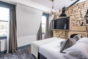 a hotel room with a bed and a fireplace at Abbey Hotel Bath, a Tribute Portfolio Hotel in Bath
