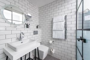 a white bathroom with a sink and a mirror at Abbey Hotel Bath, a Tribute Portfolio Hotel in Bath