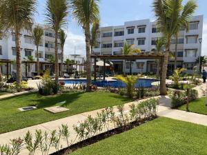 a resort with a swimming pool and palm trees at Nuevo y Muy Bonito Departamento Con Vista a la Alberca - Residencial Almarena I in Mazatlán