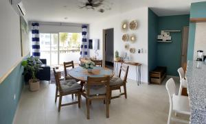 a kitchen and dining room with a table and chairs at Nuevo y Muy Bonito Departamento Con Vista a la Alberca - Residencial Almarena I in Mazatlán