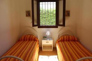 - 2 lits dans une chambre avec fenêtre dans l'établissement Villa Rosa zona Torre San Giovanni, à Torre San Giovanni