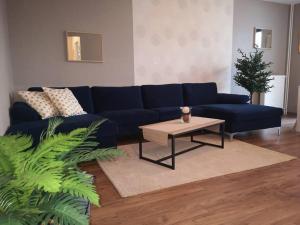 un soggiorno con divano blu e tavolino da caffè di L'Escale - appartement spacieux au calme a Brest
