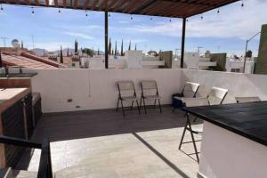 un patio avec des chaises et une table sur le toit dans l'établissement Habitación Plata #2, à Aguascalientes