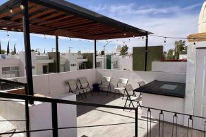 balkon z krzesłami i stołem na dachu w obiekcie Habitación Plata #2 w mieście Aguascalientes