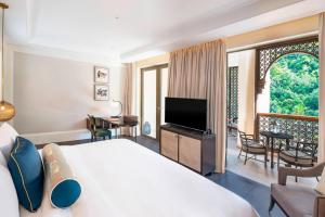 a hotel room with a large bed and a television at The St. Regis Langkawi in Kuah
