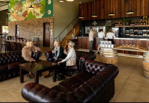 um grupo de mulheres sentadas em torno de uma mesa em um bar em Hunter Valley Resort, Hunter Farm Adventure Centre & 4 Pines at the Farm em Pokolbin