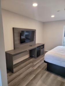 a bedroom with a flat screen tv and a bed at Five Star Inn in West Covina