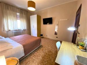 1 dormitorio con cama, mesa y TV en Casa Viola a 900 mt dalla Staz. Centrale en Pescara