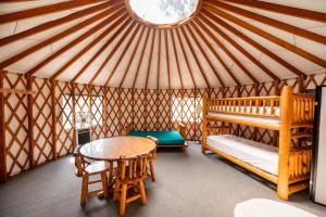 Una habitación con una yurta con una mesa y una cama en Redwood Meadows RV Resort, en Crescent City