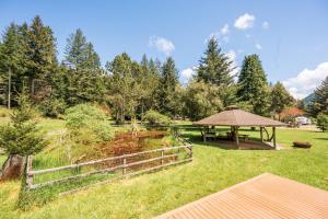 a garden with a picnic table and a gazebo at Redwood Meadows RV Resort in Crescent City
