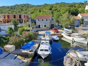 a group of boats are docked in a harbor at 19th century stone house on the seashore in Radovici