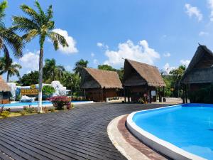 a resort with a swimming pool and two huts at Residence 8 min from the beach in Puerto Morelos