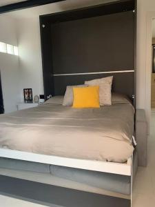 Una cama grande con una almohada amarilla. en Increíble suite, en Almuñécar