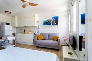 a room with a bed and a kitchen with a couch at Port de Xabia IV in Jávea