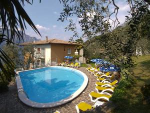 una piscina con tumbonas y una casa en Hotel Da Tino, en Malcesine