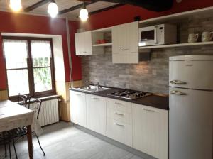 a kitchen with white cabinets and a white refrigerator at Casa Bartula in Bolzano Novarese