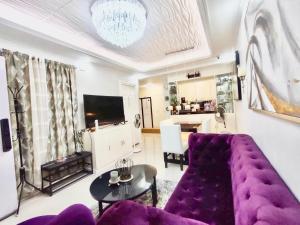 General Trias的住宿－La Maison De Rouch - Lancaster，客厅配有紫色沙发和桌子