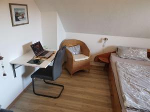 a bedroom with a bed and a desk with a laptop at Abendsonne in Dahme