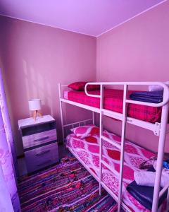 a bedroom with two bunk beds with pink walls at Acogedora casa en ica in Ica