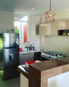 a kitchen with a stainless steel refrigerator and a stove at Acogedora casa en ica in Ica