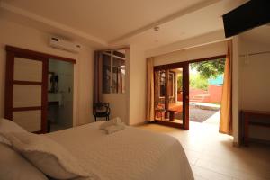 1 dormitorio con 1 cama y puerta corredera de cristal en Lava House Hostal, en Puerto Ayora