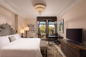 1 dormitorio con 1 cama, TV y piano en Hotel Alfonso XIII, a Luxury Collection Hotel, Seville, en Sevilla