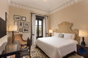 um quarto com uma cama, uma secretária e uma janela em Hotel Alfonso XIII, a Luxury Collection Hotel, Seville em Sevilha