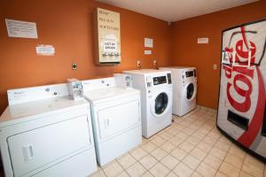 een wasruimte met wasmachines en een cokesmachine bij Americas Best Value Inn and Suites Siloam Springs in Siloam Springs