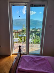 a bedroom with a balcony with a view of the ocean at Sunrise Apartments Baošići in Herceg-Novi