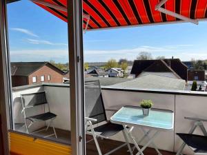 eine Terrasse mit Tisch und Stühlen auf einem Balkon in der Unterkunft Charibi - Gorch Fock in Dahme