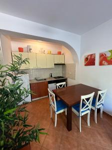 a kitchen with a table and chairs in a room at Apartments with a parking space Mali Losinj (Losinj) - 15858 in Mali Lošinj
