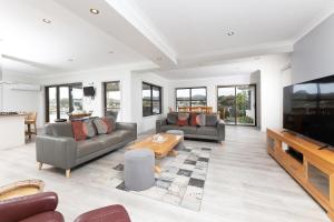 a living room with couches and a flat screen tv at 23 Elouera Crescent in Forster