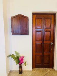 eine Holztür und eine Vase voller Blumen neben einer Tür in der Unterkunft Ocean Breeze Villa Carismar in Cabrera