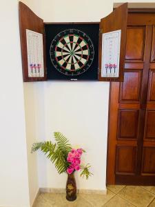 a dart board on a wall with a vase with flowers at Ocean Breeze Villa Carismar in Cabrera