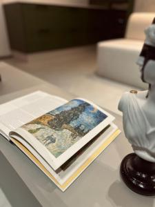 克里西烏馬的住宿－Hub Home - Vista Incrível，坐在花瓶旁边的桌子上的书
