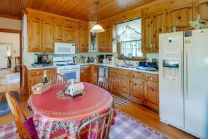 a kitchen with a table and a white refrigerator at Terre Haute Manor Farmhouse with Gardens and Deck! in Midlothian