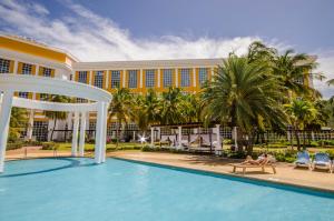 una persona tumbada en un banco junto a una piscina de hotel en Hesperia Isla Margarita en La Playa