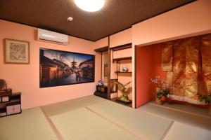 Kyoto - House - Vacation STAY 88802 في كيوتو: غرفة بجدران برتقالية ولوحة على الحائط