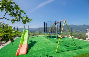 a playground with slides and swings on a green lawn at Gorgeous Home In Veliki Prolog With Kitchen in Veliki Prolog